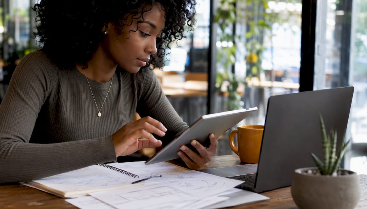 Woman reviewing e-commerce support software pricing at desk